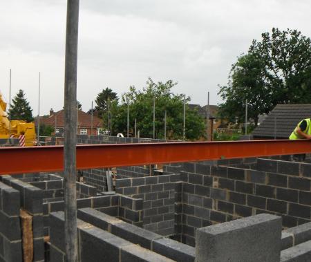 Steel girders being swung into place to form part of the major structure of the open plan living space