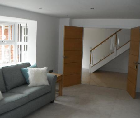 Lounge with double doors opening into spacious hallway